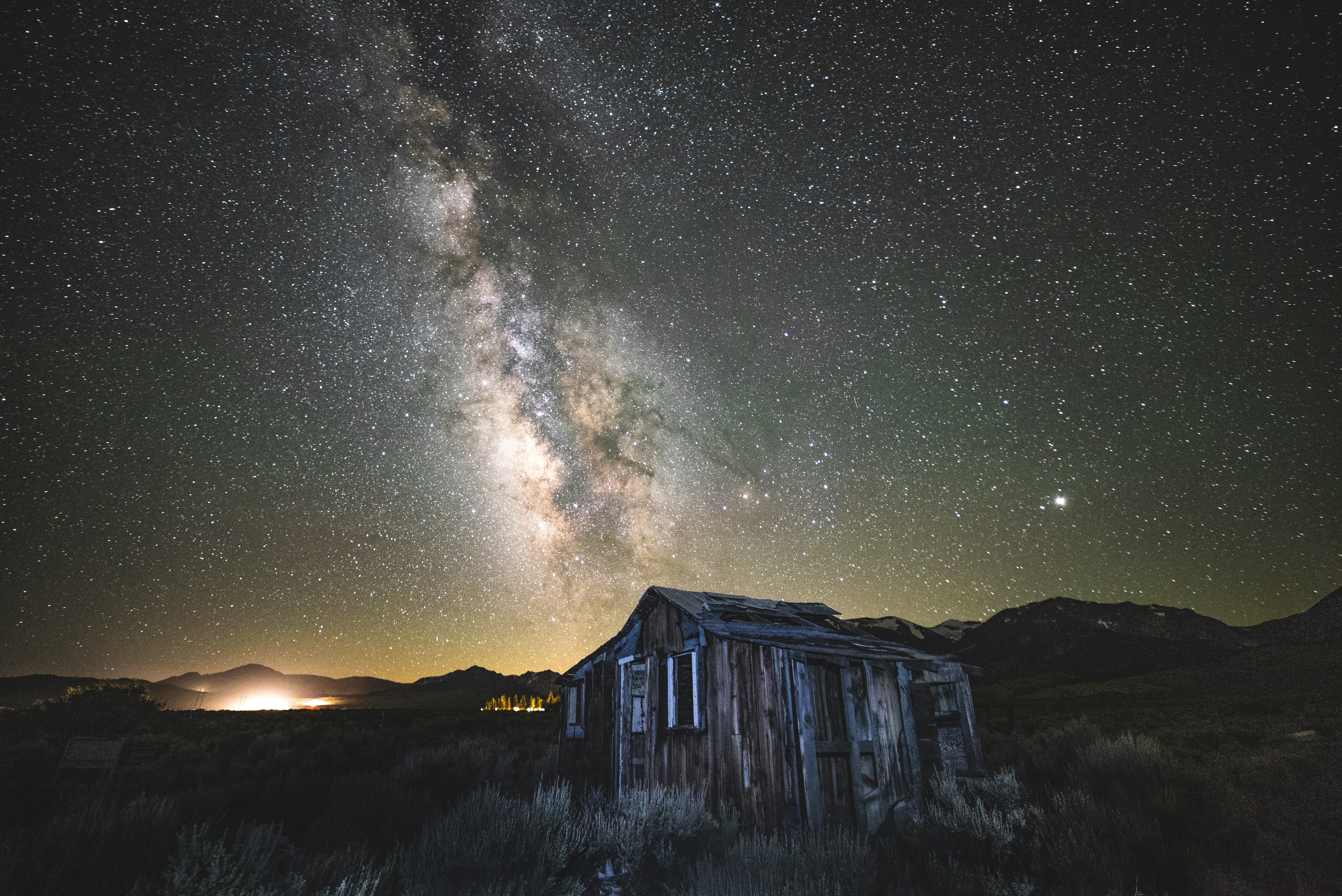 brown and gray wooden house under stars on sky during nighttime